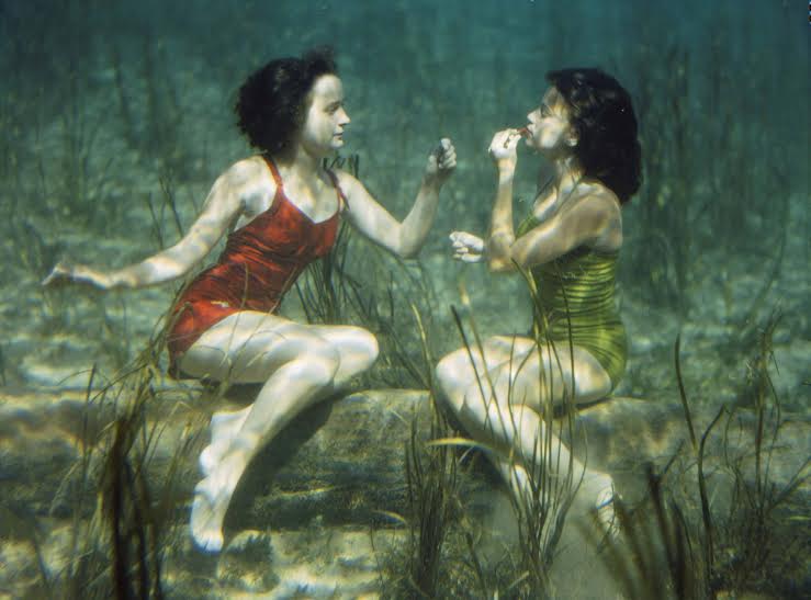 Performing swimmers put on lipstick underwater.